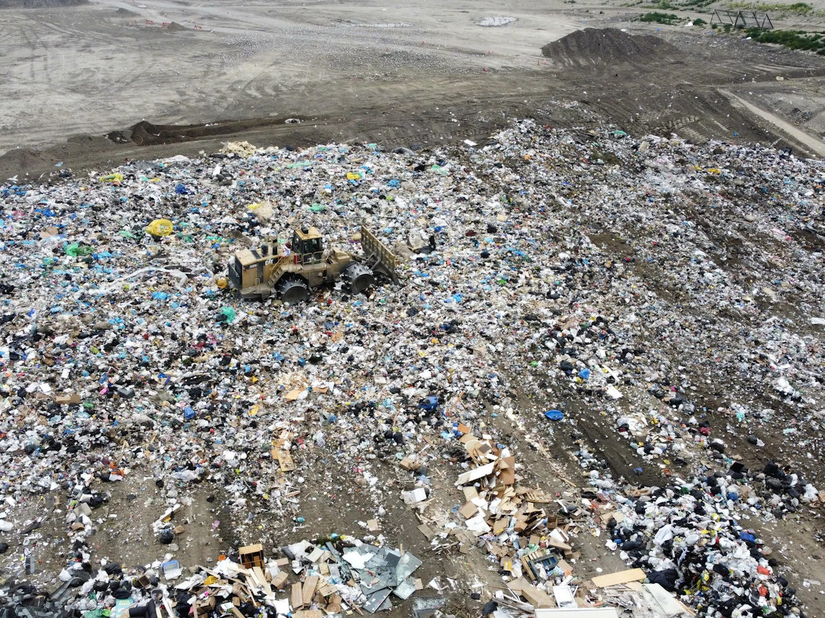 Aerial view of heavy equipment operating at an active landfill.